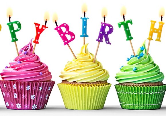 Colorful birthday cupcakes on white Row of colorful birthday cupcakes isolated on a white background