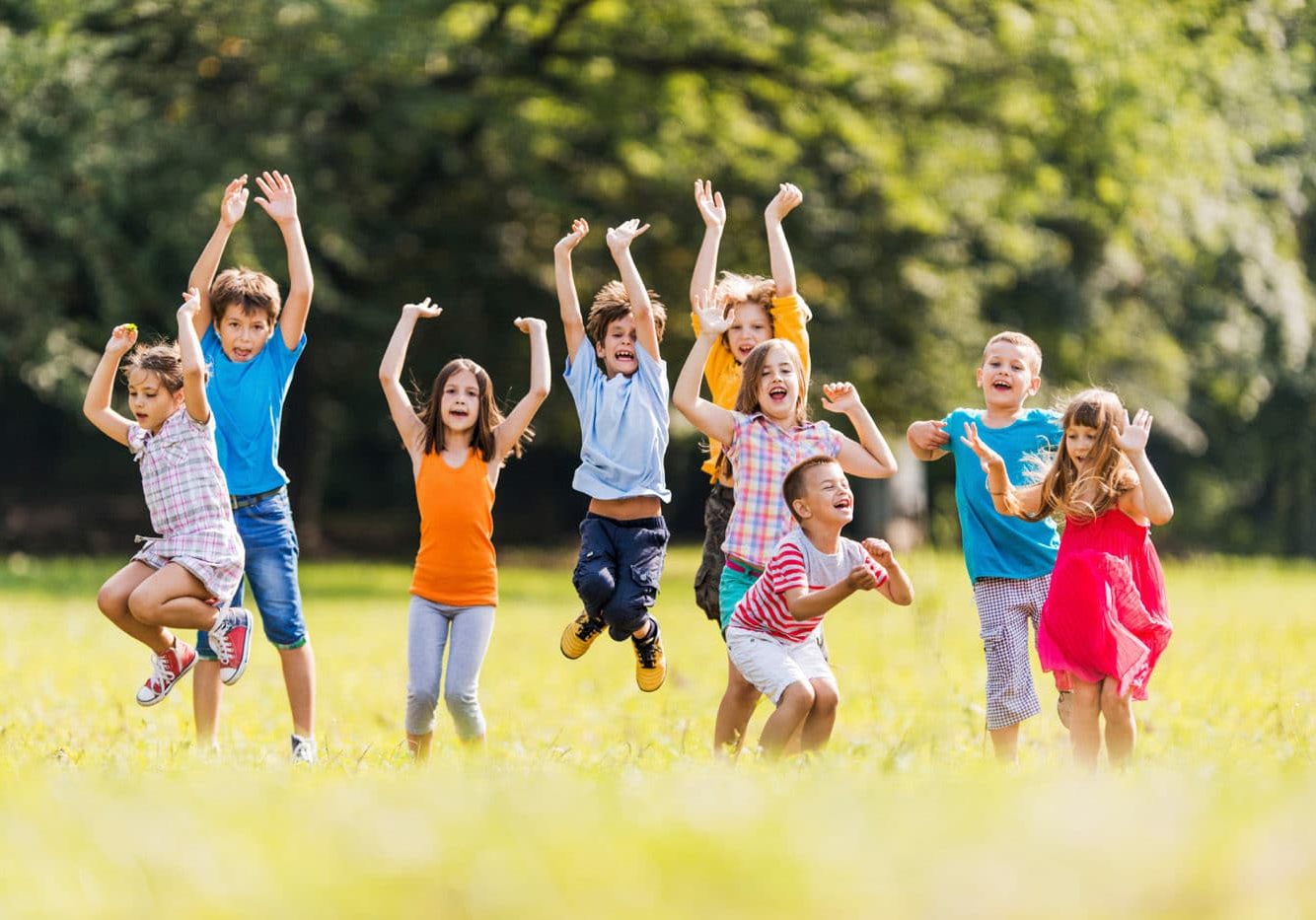 Playful Children In The Park. Large group of children jumping in the park and having fun.